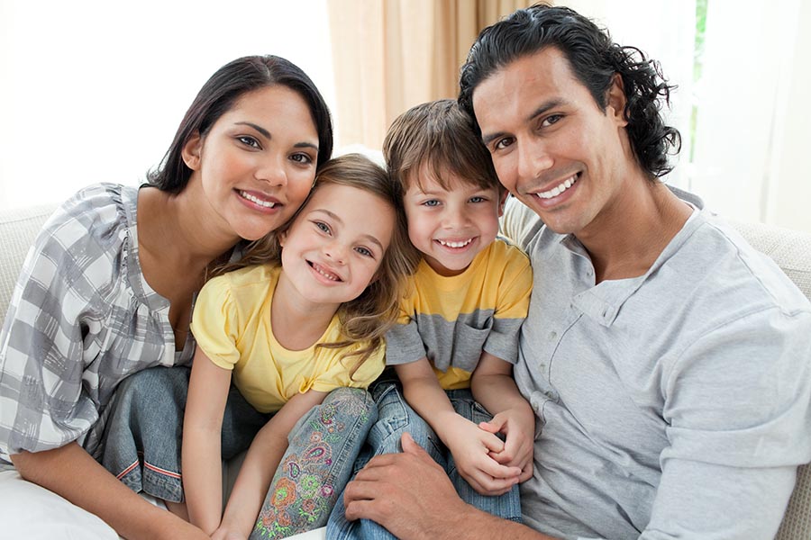 Personal Insurance - Mother, Father, Young Son and Daughter Cuddle in Close for a Family Photo, All Smiling, Dressed for Warm Weather